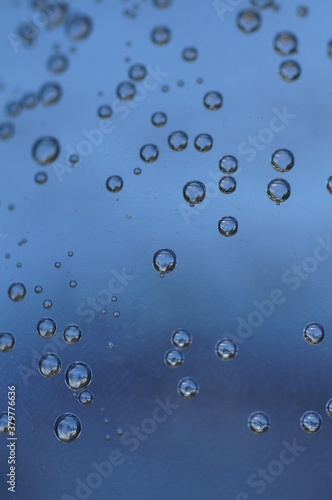 Air bubbles in a glass of water, blue and light graphite, close-up