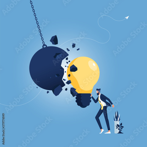 Strong creative idea metaphor and creativity strength as a wrecking ball destroyed by a light bulb as a symbol for great thinking and brainstorming