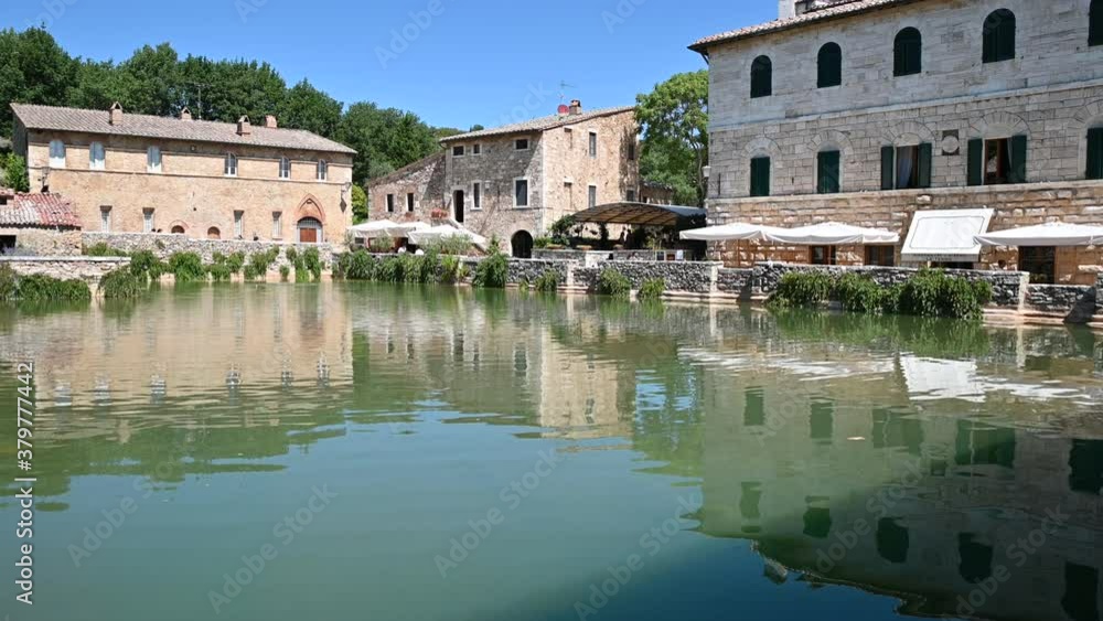 Bagno Vignoni, Tuscany, Italy. August 2020. View of the water mirror of the spring basin: here thermal water flows which fills the rectangular basin. Pan footage. Nice sunny day. Bagno Vignoni, Tuscany, Italy. August 2020. View of the water mirror of the spring basin: here thermal water flows which fills the rectangular basin. Pan footage. Nice sunny day.