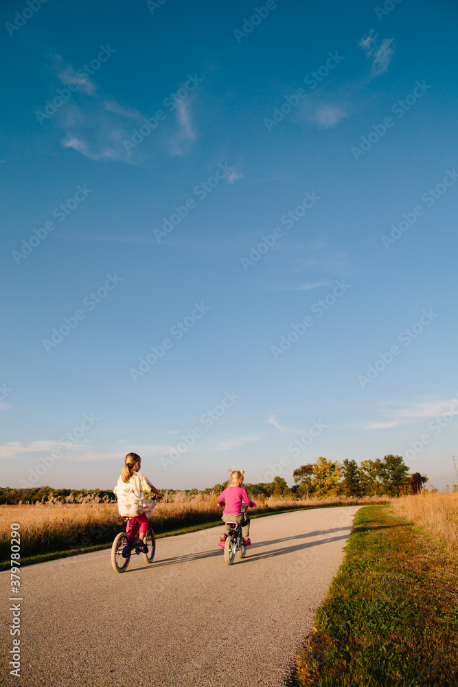 two sisters ride bikes down path two sisters ride bikes down path