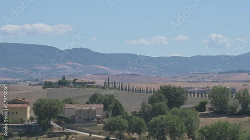 Bagno Vignoni, Tuscany, Italy. August 2020. The amazing Tuscan countryside: the footage highlights the cypress-lined avenue of a farmhouse on top of a hill. photo