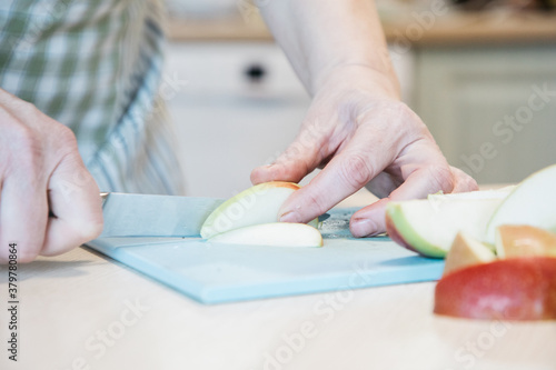 A person cutting a piece of apple on a table