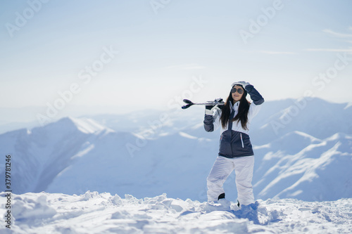 young and active brunette skiing in the snowy mountains