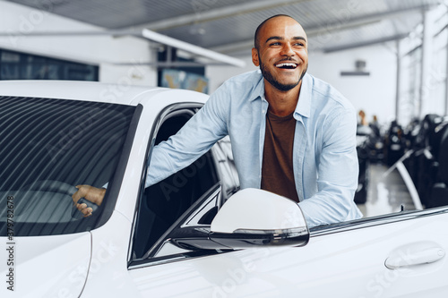 Portrait of a handsome happy African American man sitting in his newly bought car