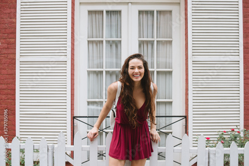 Young woman against white picket fence photo