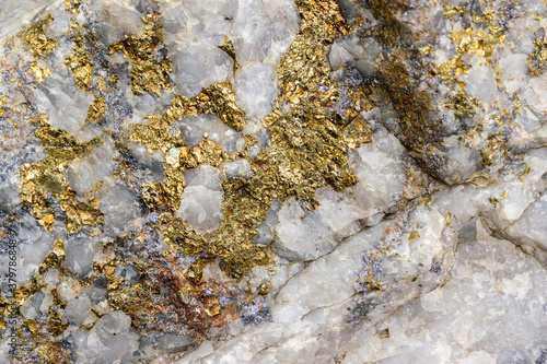 Molybdenite ore in granite. Minerals - molybdenite, pyrite, chalcopyrite, white quartz. Inclusions of gold and silver. Sorskoe deposit, Khakassia, Russia. Selective focus. photo