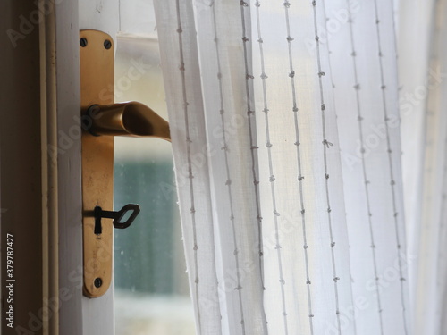 Key in golden keyhole under handlebar and curtain