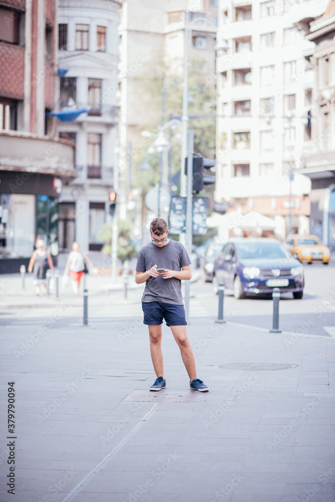 Teenager playing location-based augmented reality game on his smartphone in the city Teenager playing location-based augmented reality game on his smartphone in the city