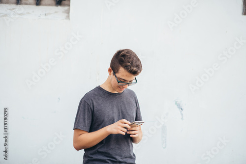 Teenager playing location-based augmented reality game on his smartphone in the city photo