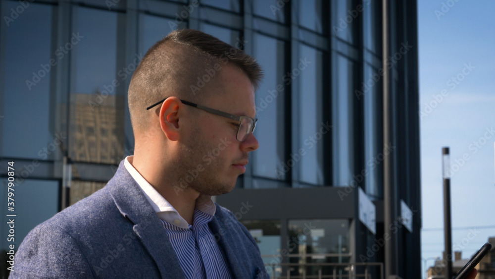 A business man in a suit is talking on a cell phone and is standing on the steps near the railing
A business man in a suit is talking on a cell phone and is standing on the steps near the railing