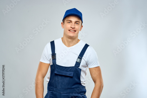 Man worker in forklift uniform delivery service light background