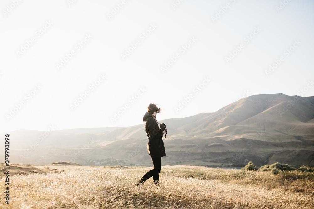 woman exploring mountainous desert landscape at sunset woman exploring mountainous desert landscape at sunset