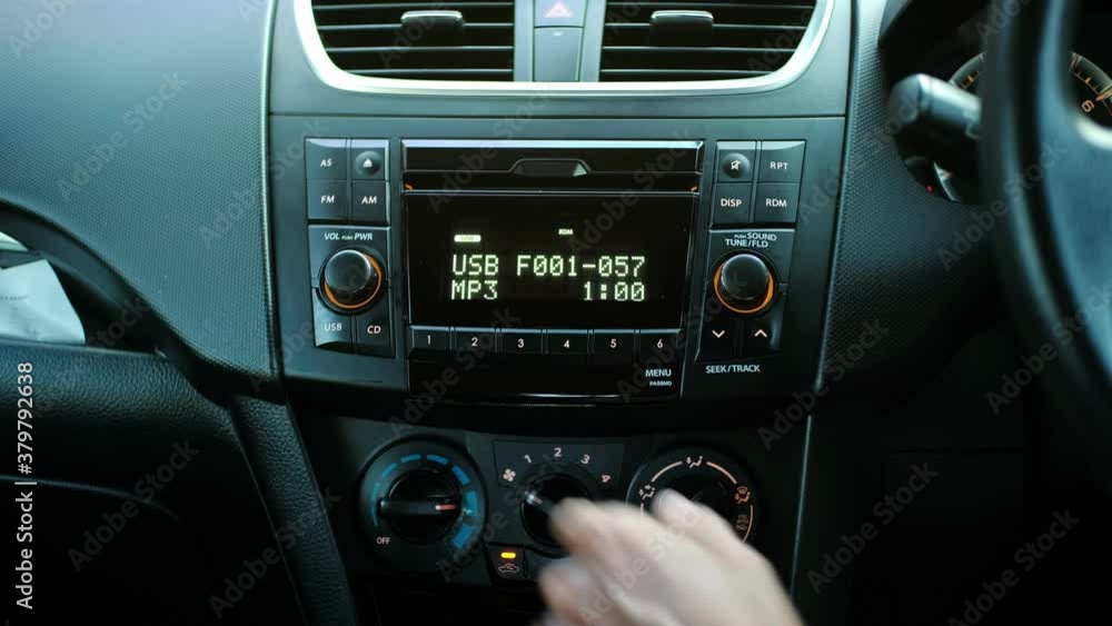 Man hand turning on the air conditioner in a car. The mans hand turns the button Man hand turning on the air conditioner in a car. The mans hand turns the button