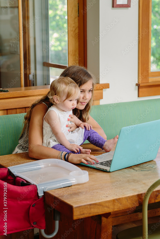 Teen Girl with Toddler Playing on Laptop Teen Girl with Toddler Playing on Laptop