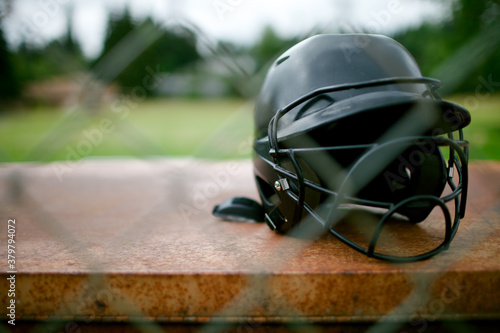 Softball helmet sits behind fence photo