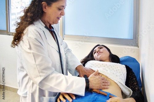 Doctor checking patien's abdomen during gastro consult photo