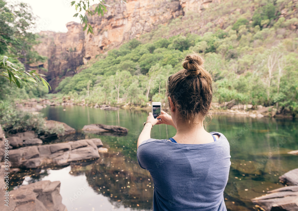 teen girl taking a photo with her cellphone at Kakadu NP, NT, Australia teen girl taking a photo with her cellphone at Kakadu NP, NT, Australia