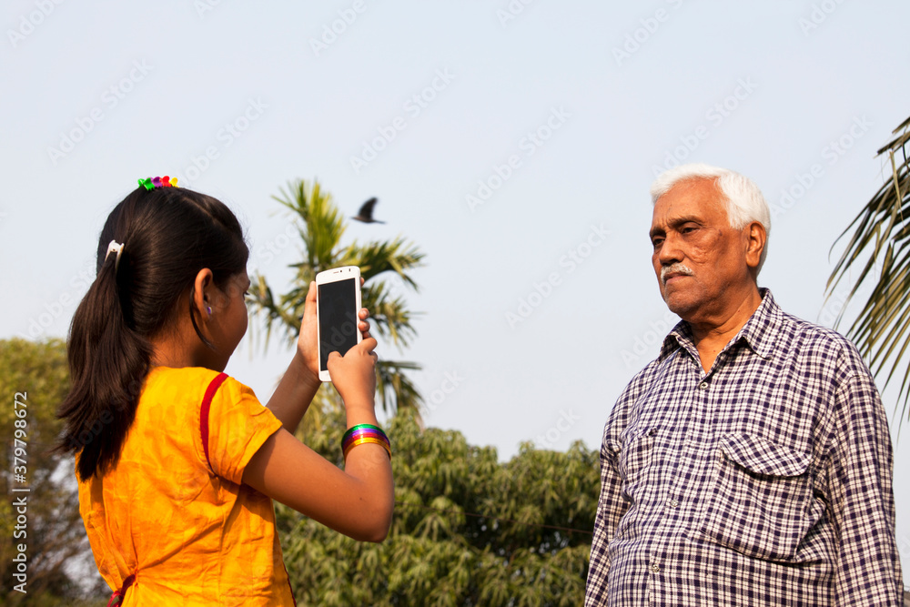 Grandchildren taking photo of Grandfather with smartphone Grandchildren taking photo of Grandfather with smartphone
