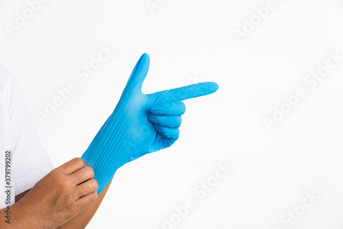Woman wearing hand to blue rubber glove with pointing finger sign