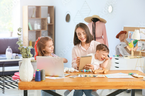 Smiling mother working from...