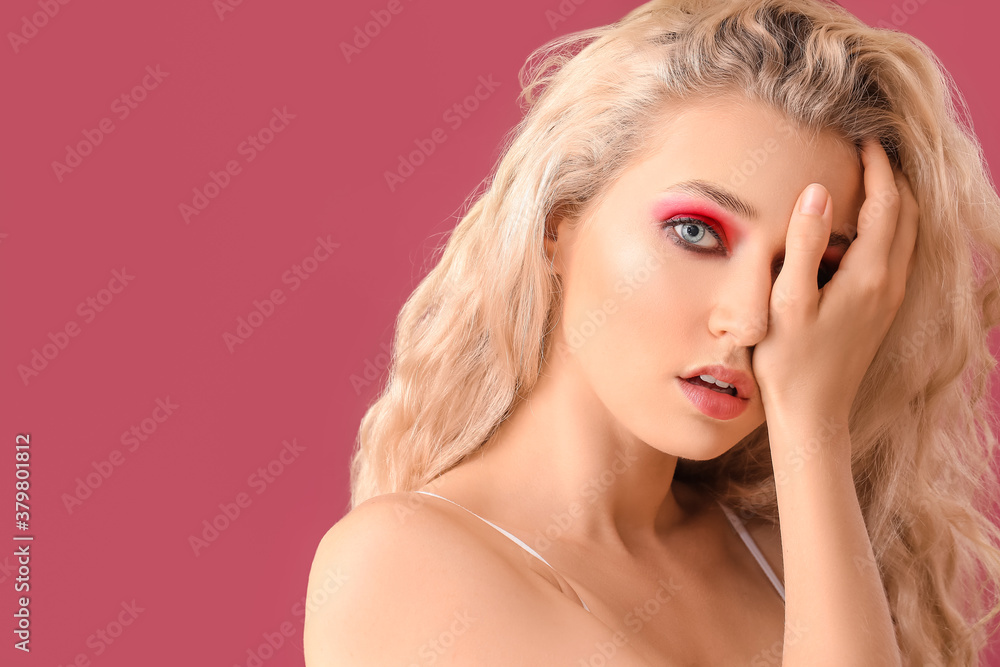Fototapeta premium Young woman with beautiful eyeshadows on color background