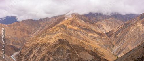 Barren cold desert mountain landscape of Spiti river mountain valley located high in rain shadowed region of Himalayas in Himachal Pradesh, India.