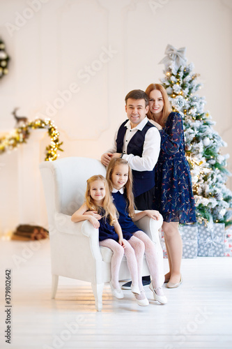 father, mother and daughters in new year decor. family photo shoot for Christmas. annual traditions of celebration. happy and fun holidays. © andrey