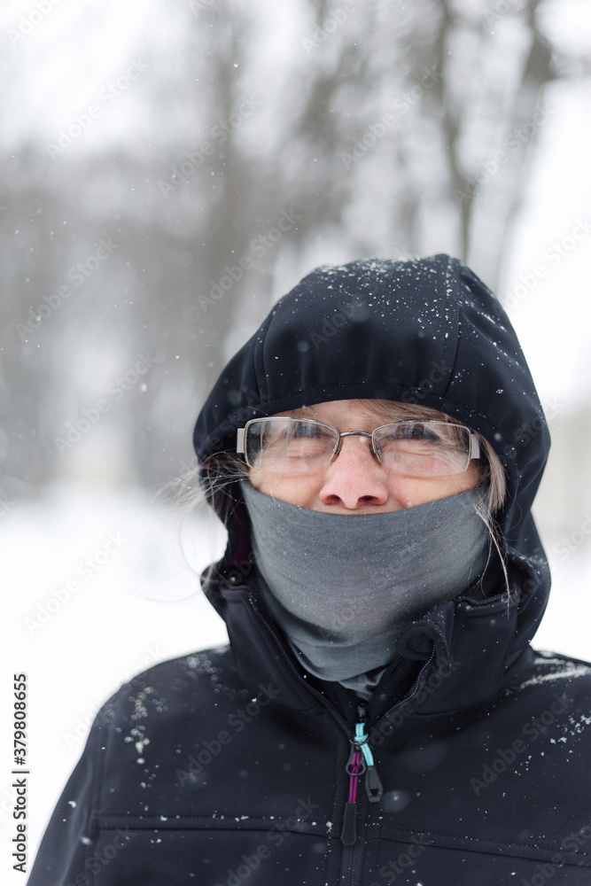 Portrait of a beautiful senior woman standing outside under the falling snow Portrait of a beautiful senior woman standing outside under the falling snow