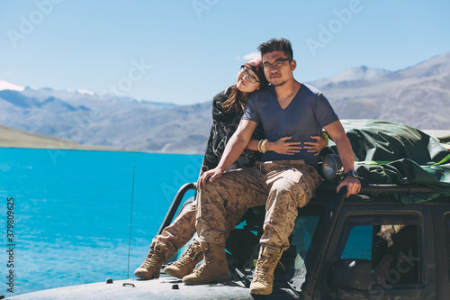 young couple sitting on the top of the car beside YamdrokTso photo