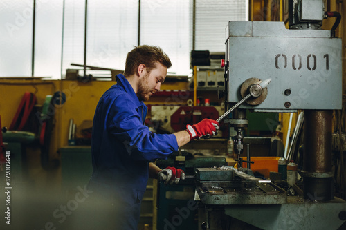 portrait of a locksmith operating a drilling machine