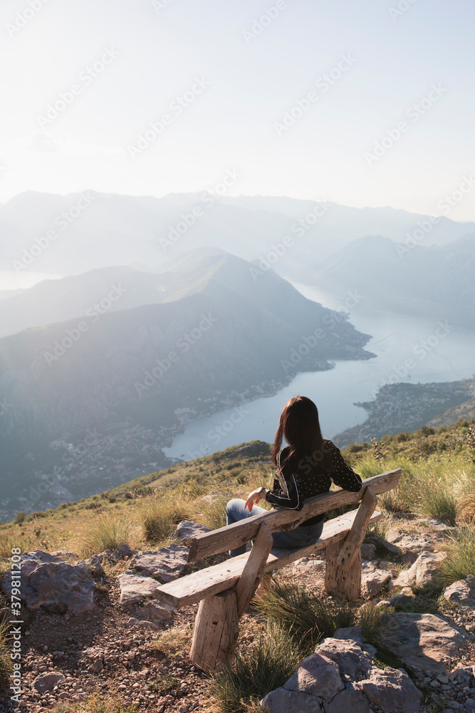 Young woman sitting on the bench with the view Young woman sitting on the bench with the view