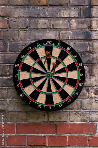 Classic darts board on brick wall photo