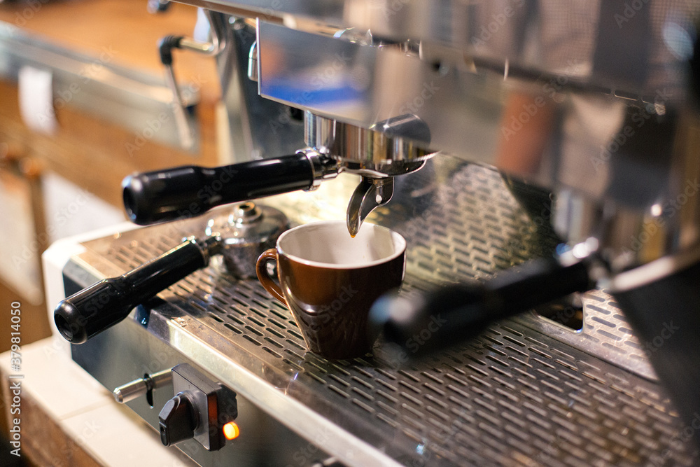Cup of coffee being prepared using an espresso machine in a cafe. Cup of coffee being prepared using an espresso machine in a cafe.