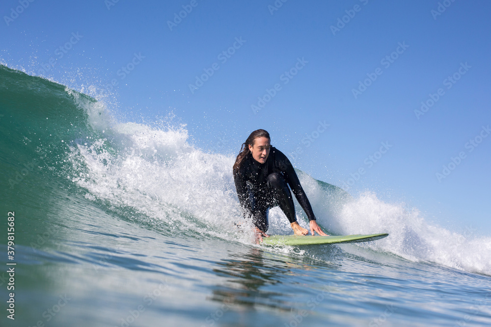 A young female surfer riding a small wave A young female surfer riding a small wave