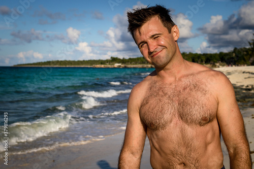 Obraz na płótnie Holguin / Cuba 10.10.2018: Handsome man is standing on the beach w salonie
