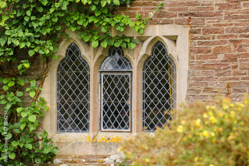Black leaded windows in a stone surround in an old medieval cottage