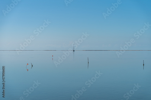 Sky reflection in the mediterranean ocean water. Relaxing background screensaver. Save the planet concept. Save the oceans. Wooden pier. Mirror water limitless. photo