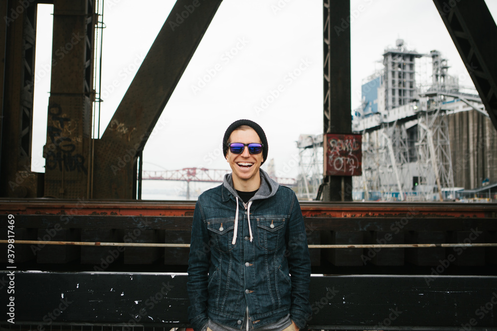 Man wearing a jean jacket standing in an urban setting Man wearing a jean jacket standing in an urban setting
