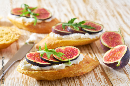 Sandwich with cream cheese, figs on a wooden table. Healthy food concept.