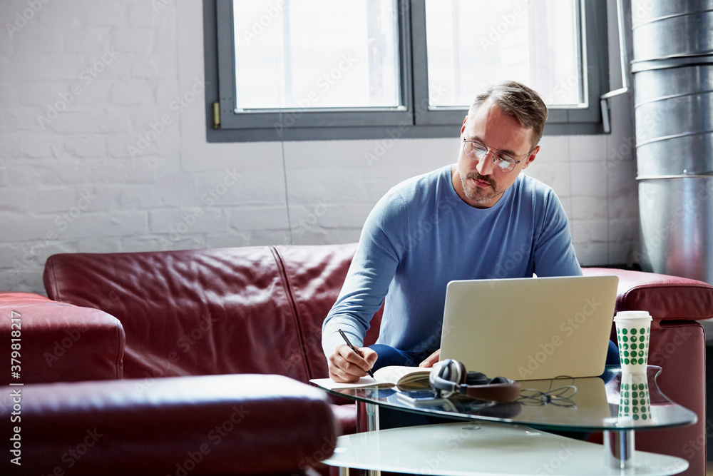 Businessman Writing In Book On Sofa At Office Businessman Writing In Book On Sofa At Office