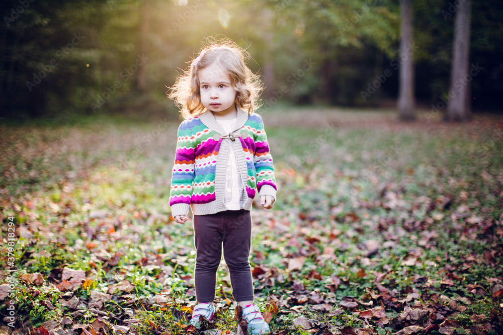 Toddler playing in a park during fall Toddler playing in a park during fall