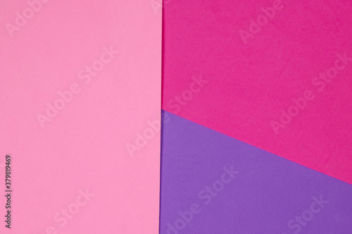 An abstract geometric textured background of pink and purple created with overlapping foam craft paper 