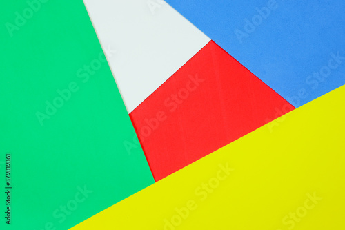 An abstract geometric textured background of red, white,blue, green and yellow colors created with overlapping foam craft paper 