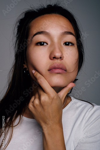 Asian woman with hand on chin photo