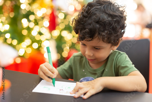 Kid write a letter on Christmas. Holiday season.
