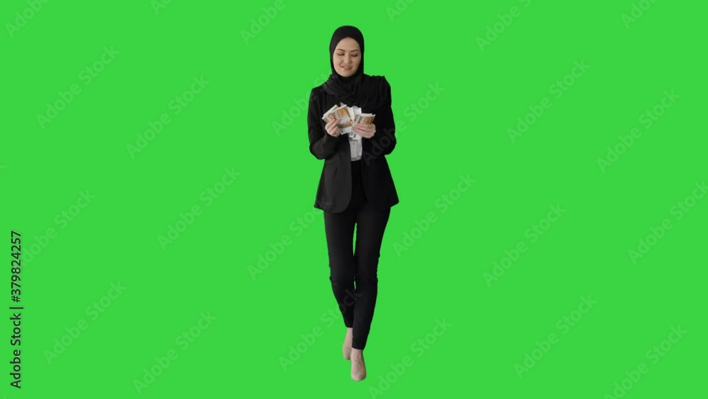 Pretty woman in hijab walking and counting money on a Green Screen, Chroma Key. Pretty woman in hijab walking and counting money on a Green Screen, Chroma Key.