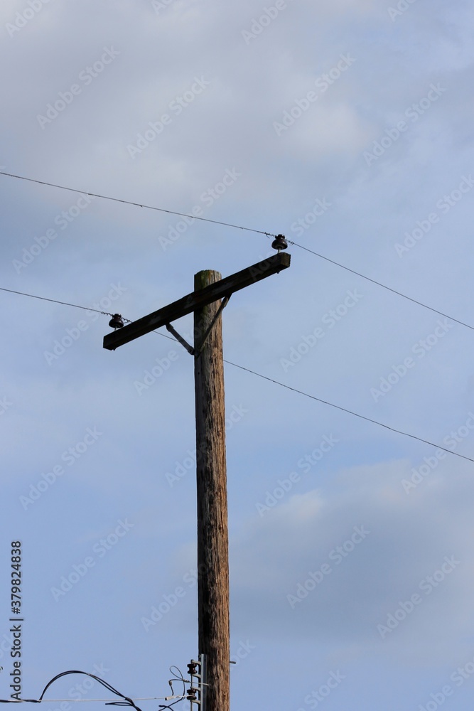 electric pole with wires with blue sky and white clouds in Hutchinson Kansas USA.