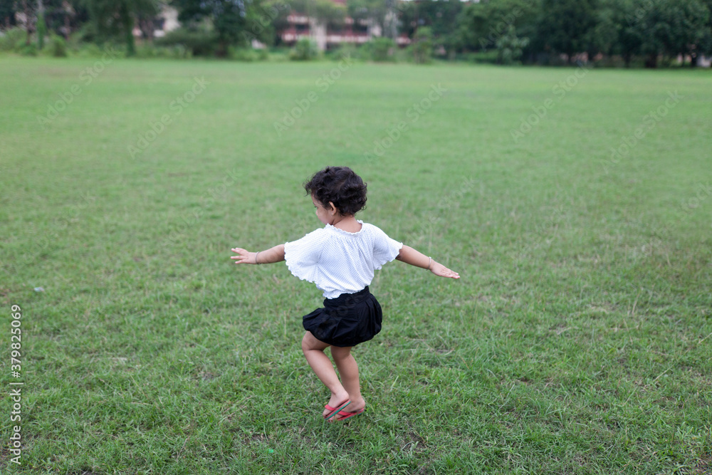 Energetic kid streatching hands and making fun at outdoor Energetic kid streatching hands and making fun at outdoor