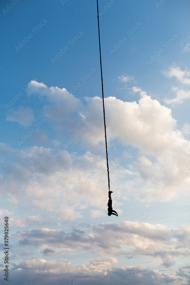 Man hangs upside down from a bungee cord Man hangs upside down from a bungee cord