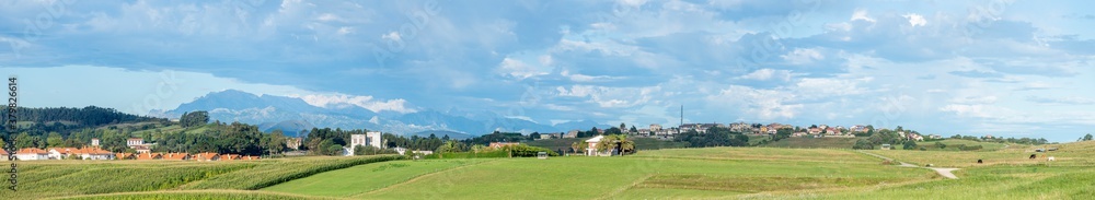 Wide panorama of Cóbreces (Alfoz de Lloredo, Cantabria) with the mountain range 'Picos de Europa' 